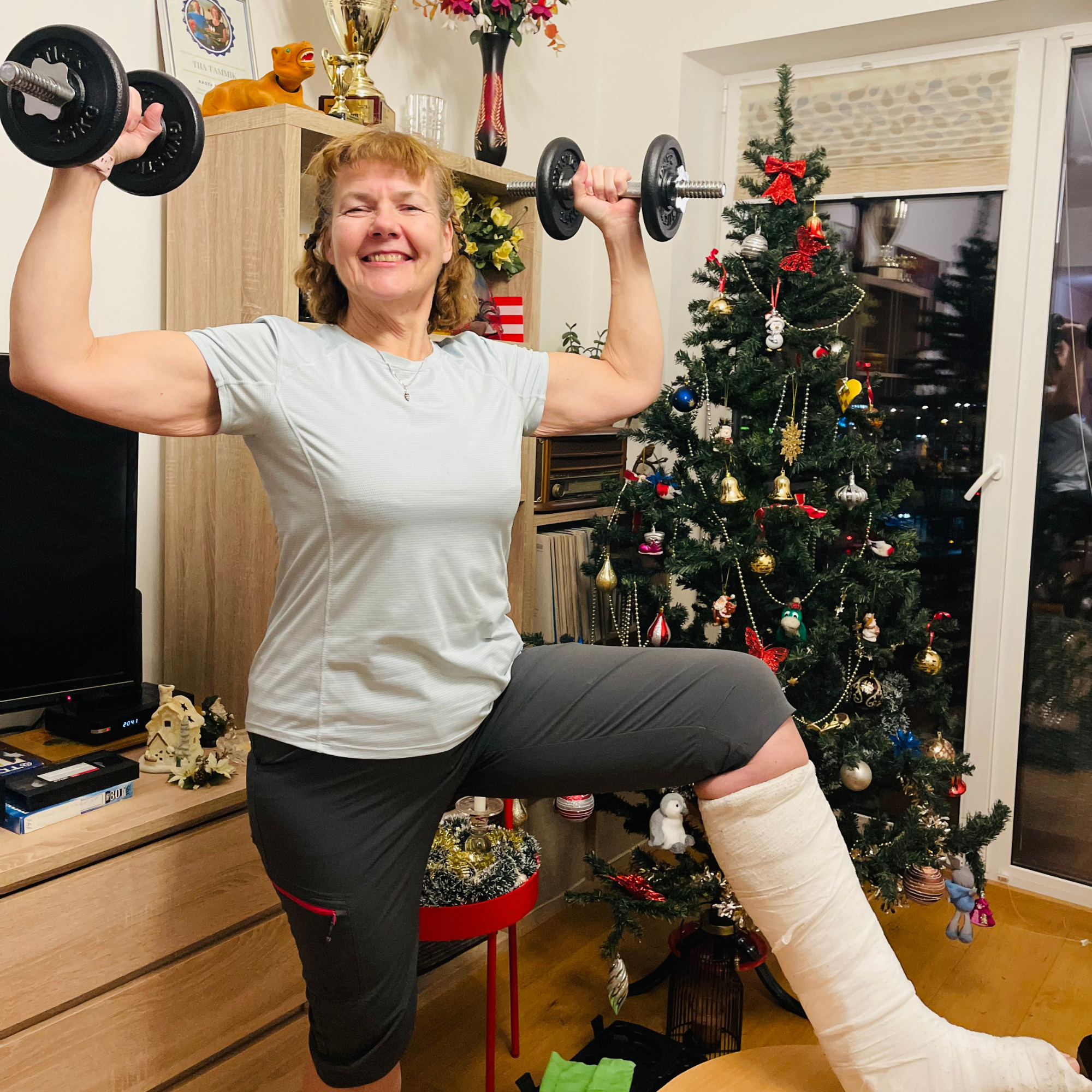 Tiia treenib kodus hantlitega, jalg kipsis